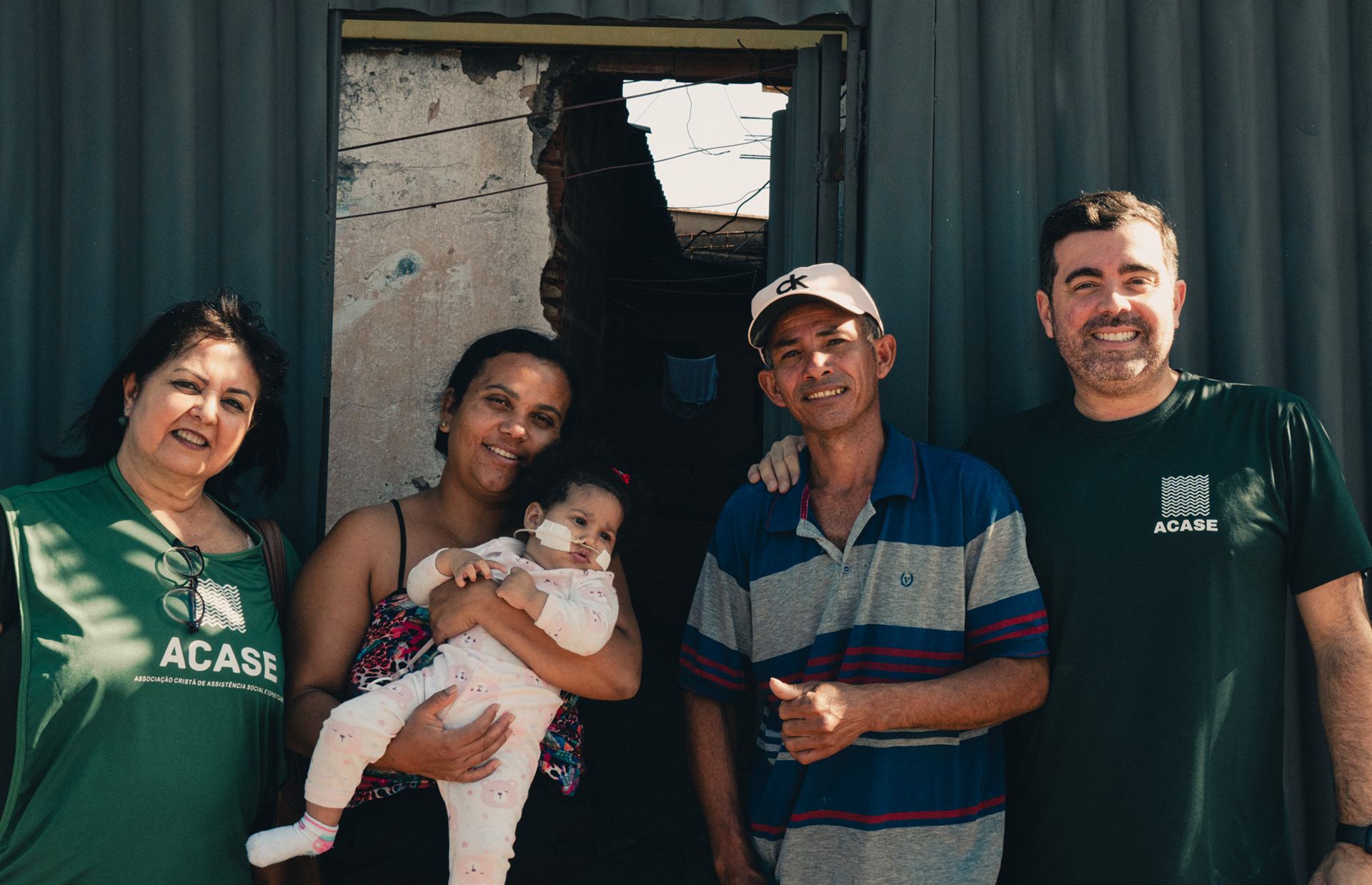 Voluntários da ACASE conversam com uma mãe e seus filhos durante visita da Casa de Jairo